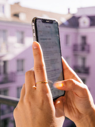 Hands scrolling a social media feed on a smartphone